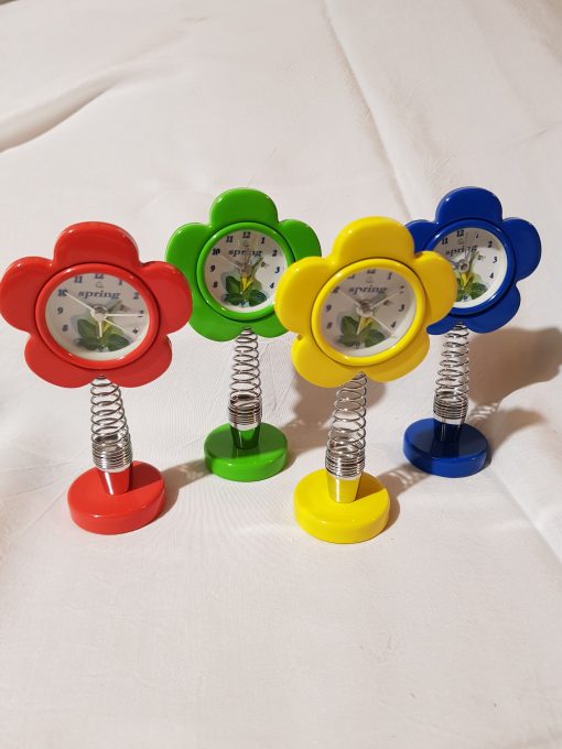 Orologio in Plastica Colorata in 4 Varianti Assortite montati con molla e Quadrante Margherita confezionati in scatola trasparente con veletta, confetti e pergamena personalizzata.